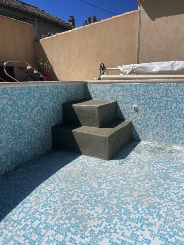 Rénovation piscine création de marche avec plage immergée en agglos maçonnés à Nîmes dans le Gard