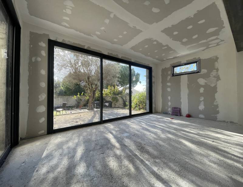 Extension de maison : pose d'une baie vitrée coulissante à triple vantail à Mouries  dans le secteur des Alpilles proche d'Arles.