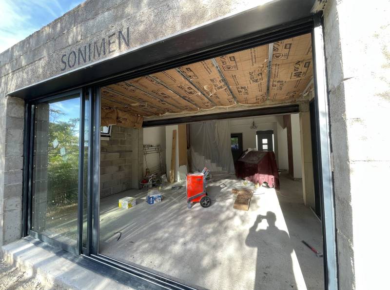 Baie vitrée coulissante à triple vantail posée par Maison Loucassie sur une extension de maison à Saint-Étienne-du-Grès dans les Alpilles